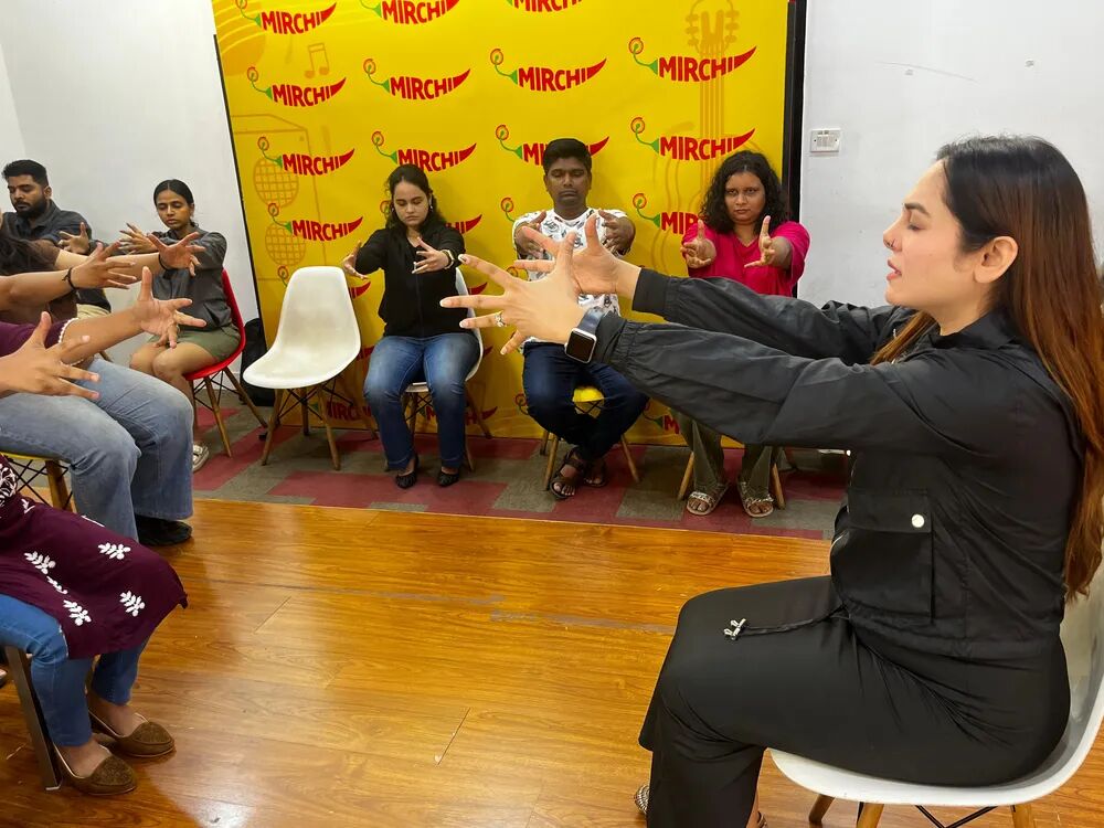 Vibha Jain speaking to a seated group during a hypnotherapy session